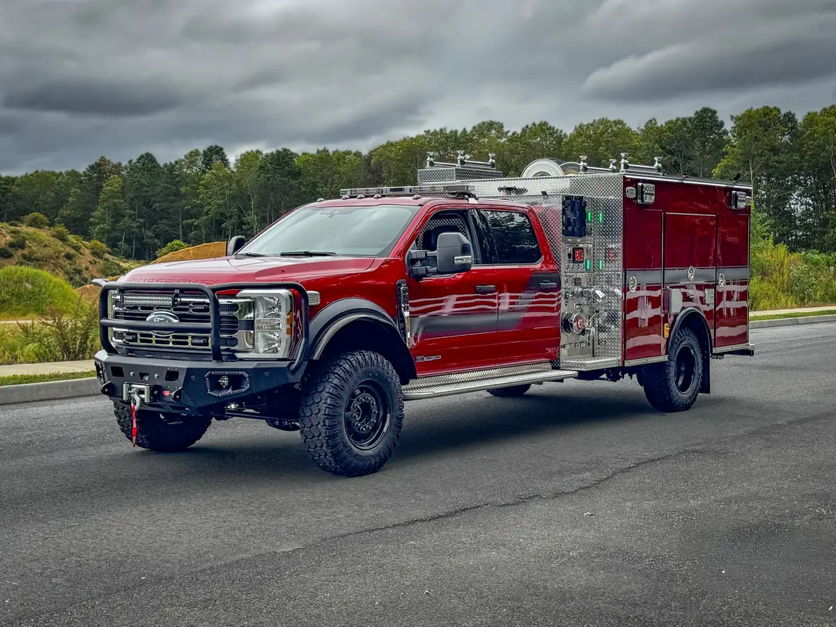 Front-right three-quarter exterior view showing cab, body, and brush guard.